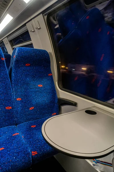 Rows of armchairs and a table near a window in the upper compartment of a two-story car of the Israeli Railways company