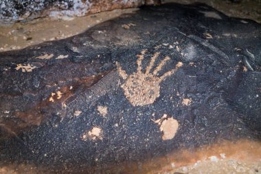 İsrail'in güneyindeki Avdat kalesi yakınlarında çölde ilkel bir adam tarafından taşa oyulmuş bir adamın el izini gösteren bir çizimin gece görüntüsü