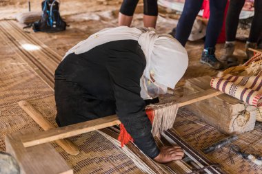 Bedevi bir kadın, Mitzpe Ramon şehrinin yakınlarındaki bir Bedevi köyünde basit bir tezgahta doğru kumaşı nasıl yapacağını gösteriyor.