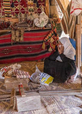Bedevi kadın, Mitzpe Ramon şehrinin yakınlarındaki bir Bedevi köyünde ilkel bir dokuma tezgahının yanında oturuyor.