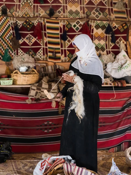 Egy beduin nő megmutatja, hogyan kell helyesen fonalat fonni a régi módon egy beduin faluban, a Mitzpe Ramon város közelében. — Stock Fotó