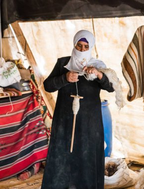 Bedevi bir kadın, Mitzpe Ramon şehrinin yakınlarındaki bir Bedevi köyünde eski usul yün iplik yapmayı öğretiyor.