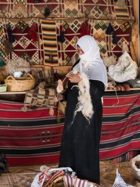 Bedevi bir kadın, Mitzpe Ramon şehrinin yakınlarındaki bir Bedevi köyünde eski usul yün iplik yapmayı öğretiyor.