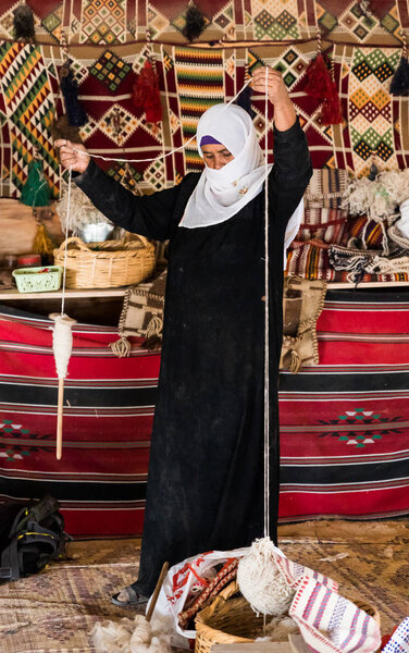 Бедуинская женщина показывает, как правильно сделать нить из шерсти по-старому в бедуинской деревне недалеко от города Мицпе Рамон
