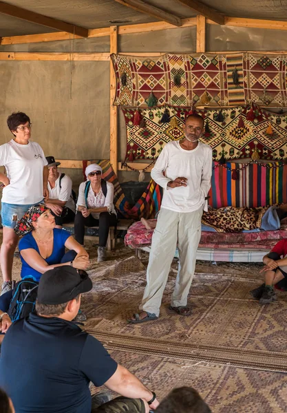 Beduíno diz aos turistas sobre a vida em uma aldeia beduína perto da cidade de Mitzpe Ramon — Fotografia de Stock