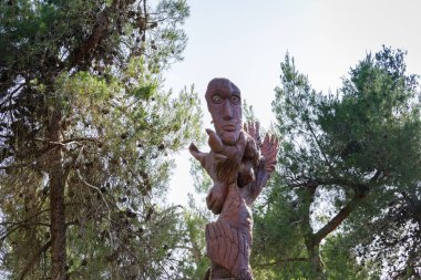Kudüs, İsrail, 13 Haziran 2020: Har Adar ve Abu Ghosh köylerinin yakınlarındaki Totem parkında çeşitli şekillerde oyulmuş ayakta duran tahta bir sütun.