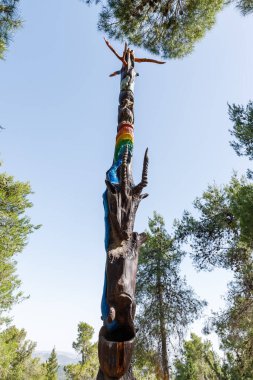 Kudüs, İsrail, 13 Haziran 2020: Har Adar ve Abu Ghosh köylerinin yakınlarındaki Totem parkında çeşitli şekillerde oyulmuş ayakta duran tahta bir sütun.