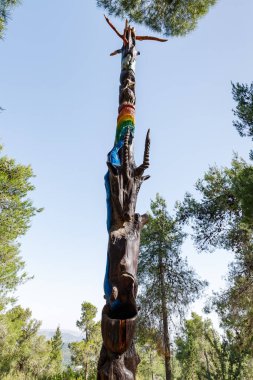 Kudüs, İsrail, 13 Haziran 2020: Har Adar ve Abu Ghosh köylerinin yakınlarındaki Totem parkında çeşitli şekillerde oyulmuş ayakta duran tahta bir sütun.