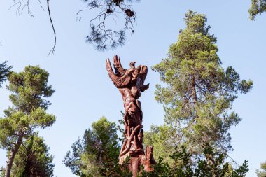 Kudüs, İsrail, 13 Haziran 2020: Har Adar ve Abu Ghosh köylerinin yakınlarındaki Totem parkında çeşitli şekillerde oyulmuş ayakta duran tahta bir sütun.