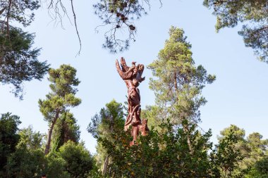 Kudüs, İsrail, 13 Haziran 2020: Har Adar ve Abu Ghosh köylerinin yakınlarındaki Totem parkında çeşitli şekillerde oyulmuş ayakta duran tahta bir sütun.