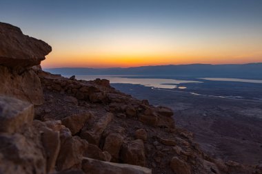 Ürdün dağlarının ve Ölü Deniz 'in üzerinden şafak sökerken. İsrail 'deki Massada Kalesi' nin harabelerinin bölgesinden görüş..