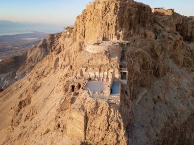 Massada harabelerinin havadan görünüşü Büyük Herod tarafından Ölü Deniz kıyısındaki bir uçurumun tepesine inşa edilmiş bir kaledir. M.S. 1. yüzyılda Romalılar tarafından yok edildi ve UNESCO Dünya Mirasları Listesi 'ne dahil edildi.