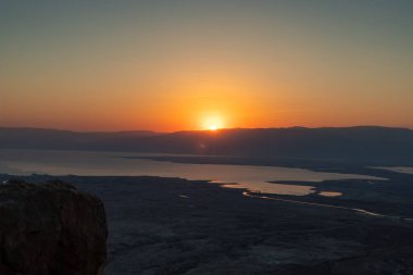 Ürdün dağlarının ve Ölü Deniz 'in üzerinden şafak sökerken. İsrail 'deki Massada Kalesi' nin harabelerinin bölgesinden görüş..