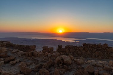 Ürdün dağlarının ve Ölü Deniz 'in üzerinden şafak sökerken. İsrail 'deki Massada Kalesi' nin harabelerinin bölgesinden görüş..