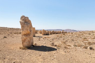 Büyük kayalar, şafak vakti, İsrail 'deki Mitzpe Ramon yakınlarındaki Judean Çölü' nün üzerindeki bir uçurumda, halka açık bir heykel parkında belirli bir sırada dururlar..