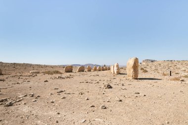 Büyük kayalar, şafak vakti, İsrail 'deki Mitzpe Ramon yakınlarındaki Judean Çölü' nün üzerindeki bir uçurumda, halka açık bir heykel parkında belirli bir sırada dururlar..