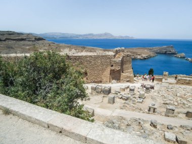 Rhodes, Greece, July 04, 2011 : Tourists examine the ruins Acropolis city fortress in Lindos city on the Rhodes island in the Greece
