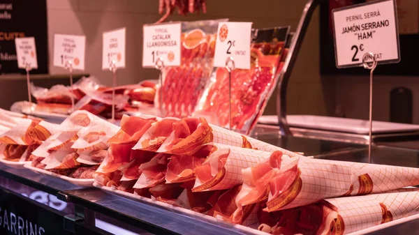 Boqueria market, jamon and sausages on the counter of the Spanish market