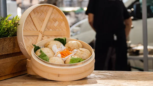 Steamed stuff bun bao pork with chopsticks on wooden board background, Natural lights Foods concept.