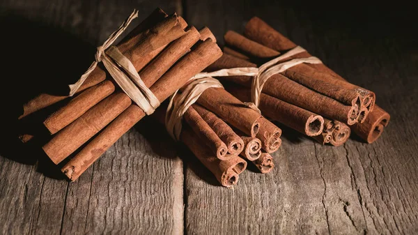 Cinnamon sticks on a wooden background. Low key lighting