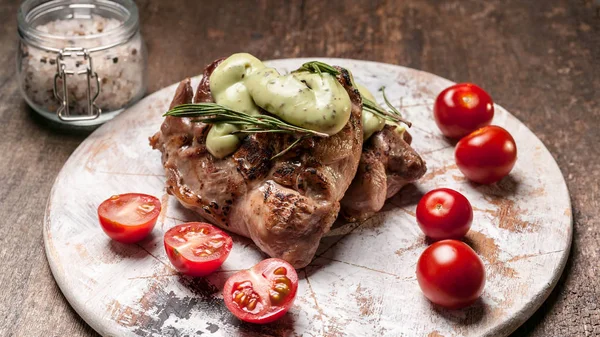 Food banner. Roasted turkey meat with arugula and rosemary sauce on a round wooden board