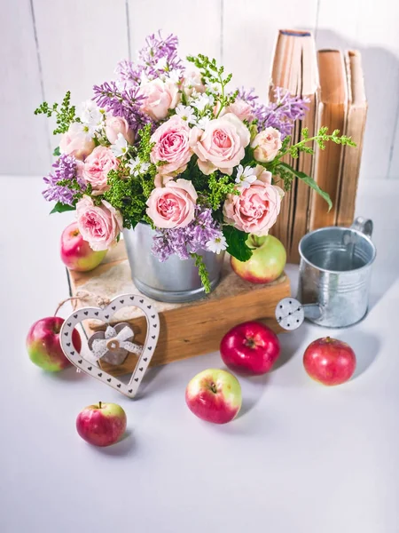 Vintage still life. Roses, lilacs, old books and apples