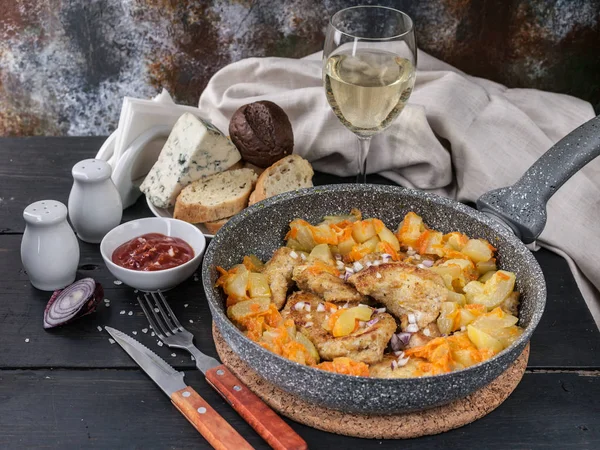 Chicken meat with stewed curry with vegetables in a pan, cheese, bread and white wine. Horizontal shot