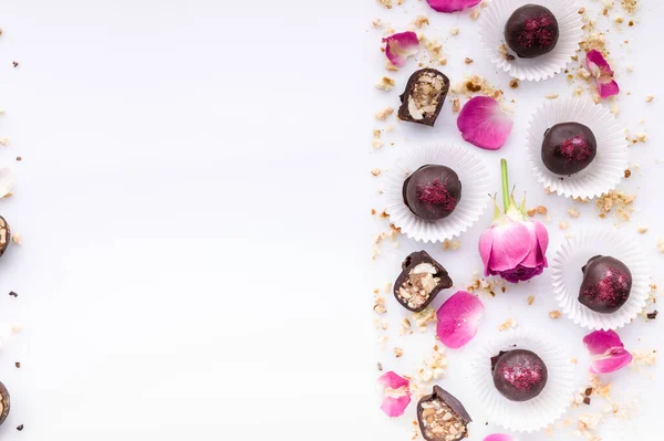 Sweet pattern. Top view handmade chocolate candies with nuts and honey. Gourmet chocolates on a white background. Close-up. Soft focus. Copy space