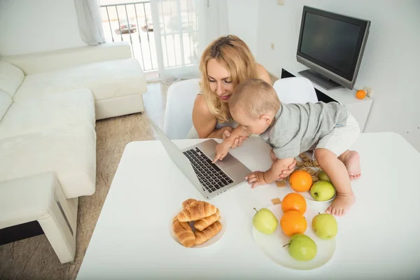 Mom turned on her little son a cartoon on a laptop