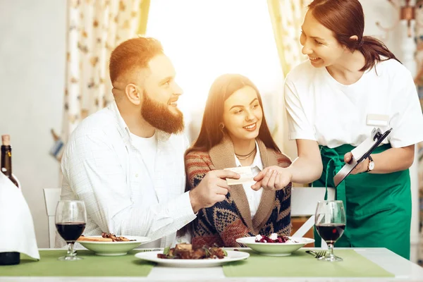 La cameriera ha portato un conto alla coppia per cena. — Foto Stock