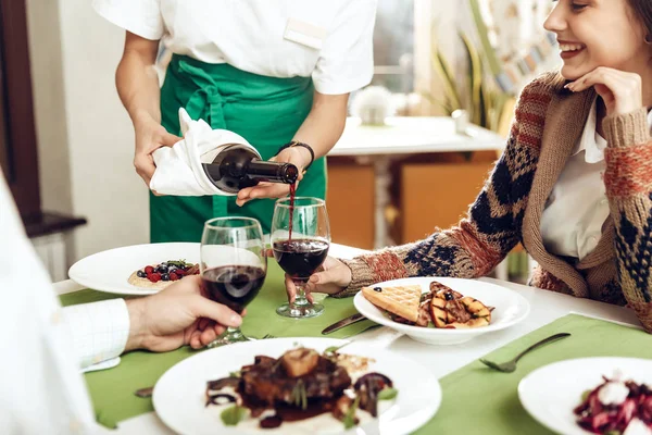 Ragazza cameriere versa vino a una coppia innamorata — Foto Stock