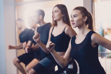 Kadın ve erkekler grup gerçekleştirir fiziksel egzersiz.