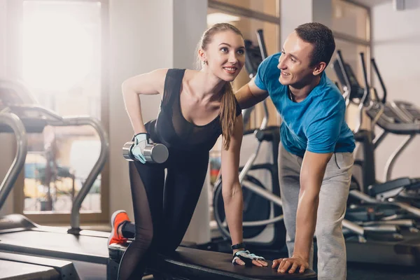 El entrenador ayuda a la chica a hacer el ejercicio . — Foto de Stock