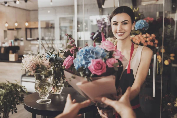 Bella fiorista ragazza invia bouquet al compratore — Foto Stock