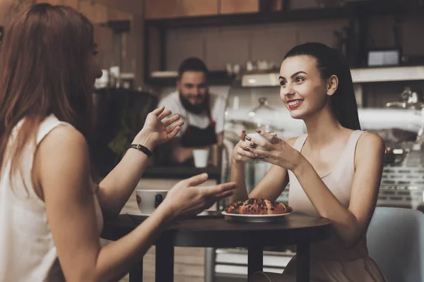 Due giovani ragazze comunicano in un caffè a tavola — Foto Stock