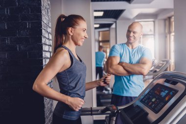 Bir koşu bandı üzerinde bir eğitmen ile kişisel eğitim