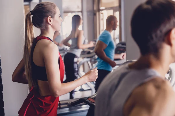 Grupo de hombres y niñas realizan ejercicios de una cinta de correr — Foto de Stock