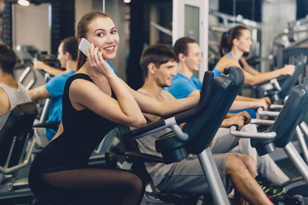 Girl is talking on a mobile phone during a workout — Stock Photo, Image