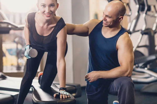 El entrenador ayuda a la chica a hacer el ejercicio . — Foto de Stock