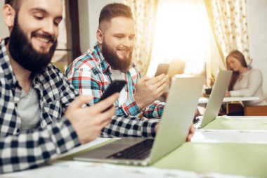 Cep telefonları bir kafede oturan iki adam bak