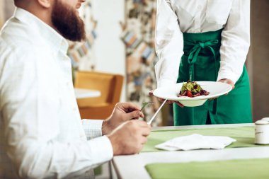 Kız garson onun yemek restoranda birine hizmet vermektedir