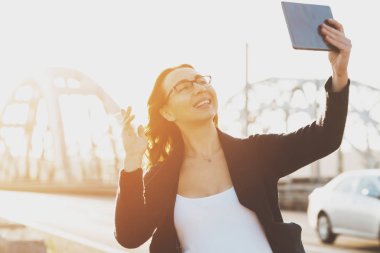 Genç gülümseyen kız selfie fotoğraf tablete yapar.
