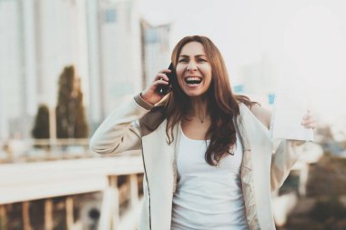 Telefonda kız arka plan üzerinde binalar.