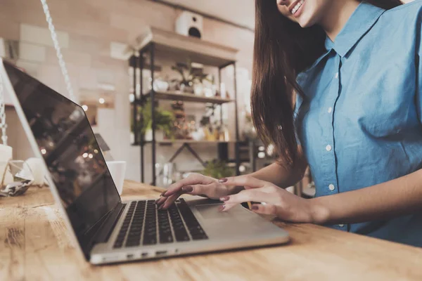 Una chica trabaja en un portátil mientras está en un café — Foto de Stock