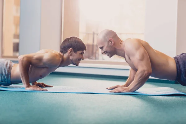 Dwóch mężczyzn będzie wykonywać trening fitness w siłowni — Zdjęcie stockowe