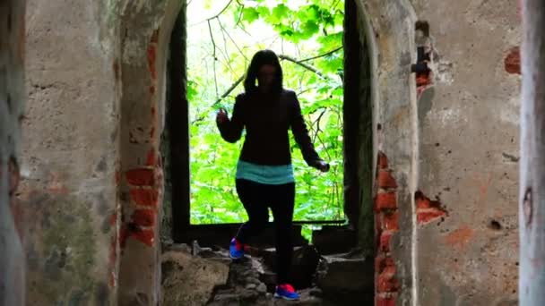 Turista em uma jaqueta de couro passa pelo portão de pedra das favelas — Vídeo de Stock