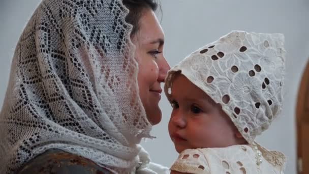 La mère tient l'enfant dans ses bras pendant le rituel de l'insulte — Video
