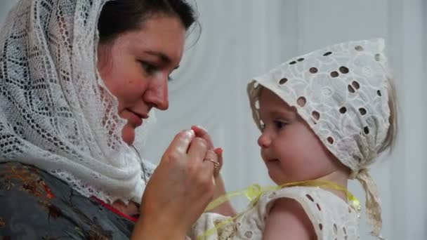 Una giovane madre gioca con il suo bambino tenendolo tra le braccia — Video Stock