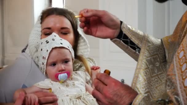 圣洁的父亲涂抹他的额头和处理的婴儿与教会油 — 图库视频影像
