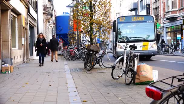 Mensen lopen langs het trottoir van een straat vol geparkeerde fietsen — Stockvideo